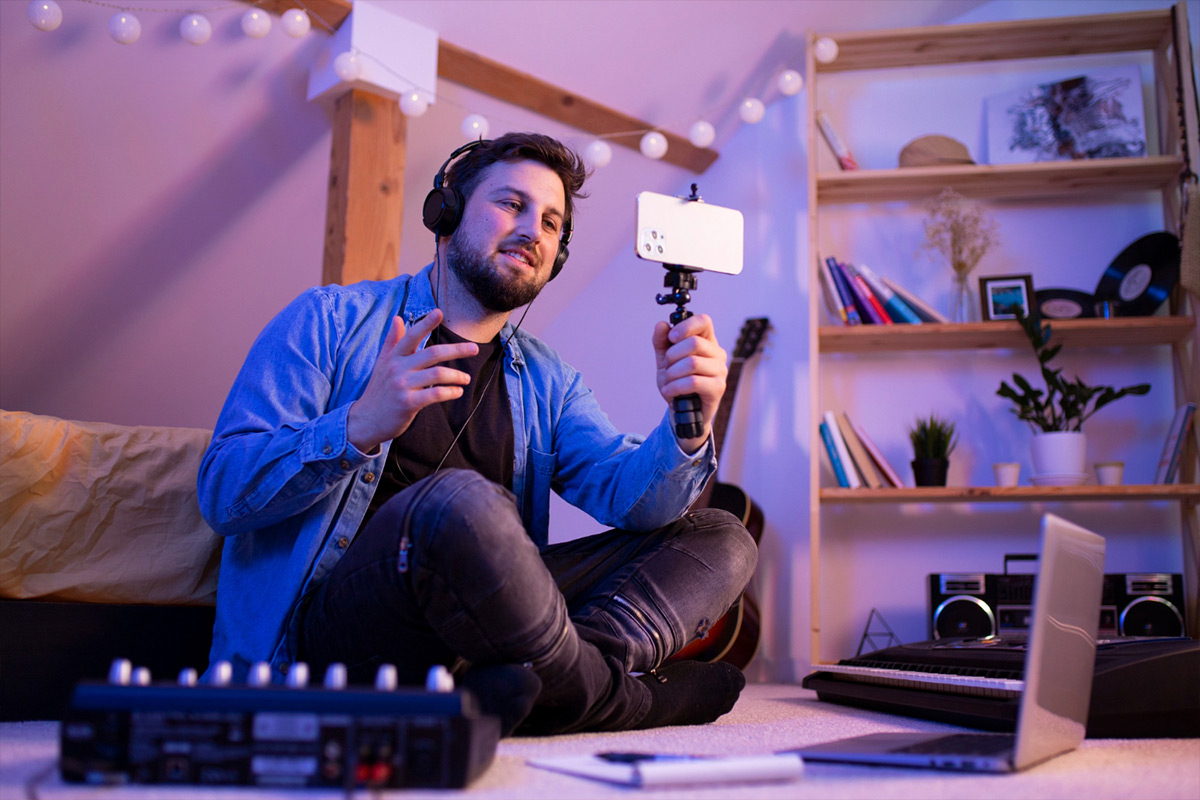 Homem fazendo live em casa com smartphone e fone de ouvido, criando conteúdo para plataformas de streaming como YouTube, Twitch e Bigo Live.