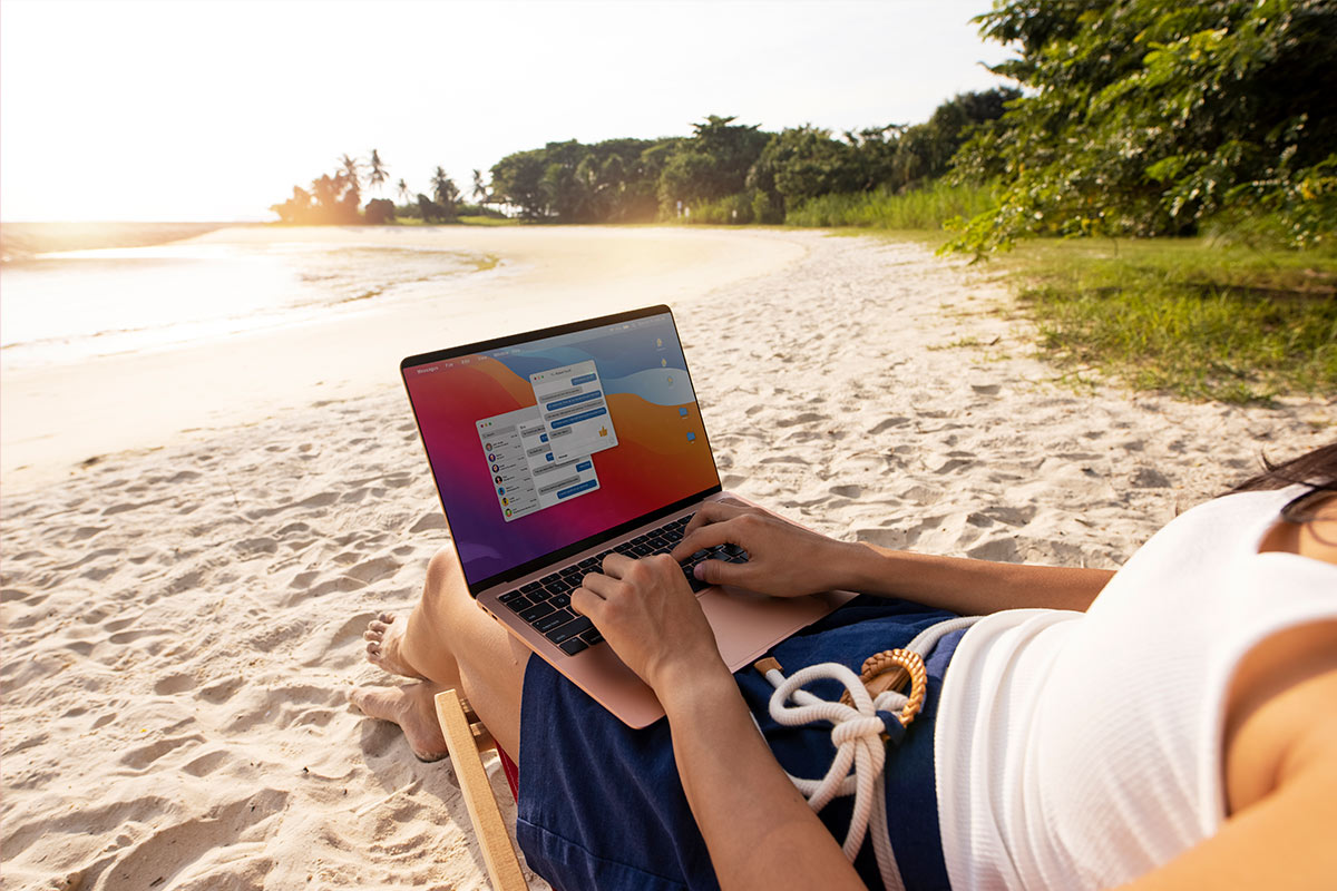 Pessoa trabalhando remotamente com notebook na praia, simbolizando o estilo de vida de um nômade digital em 2025