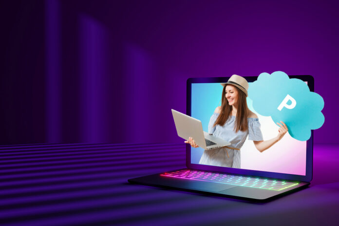mulher-sorridente-computador-pcloud Mulher sorridente saindo da tela de um laptop com ícone de nuvem azul representando o pCloud, simbolizando armazenamento seguro em nuvem