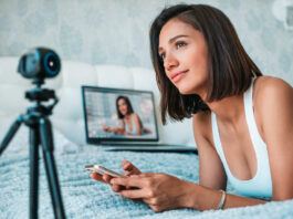 Mulher trabalhando com transmissões ao vivo pelo celular e webcam, representando como ganhar dinheiro como camgirl online